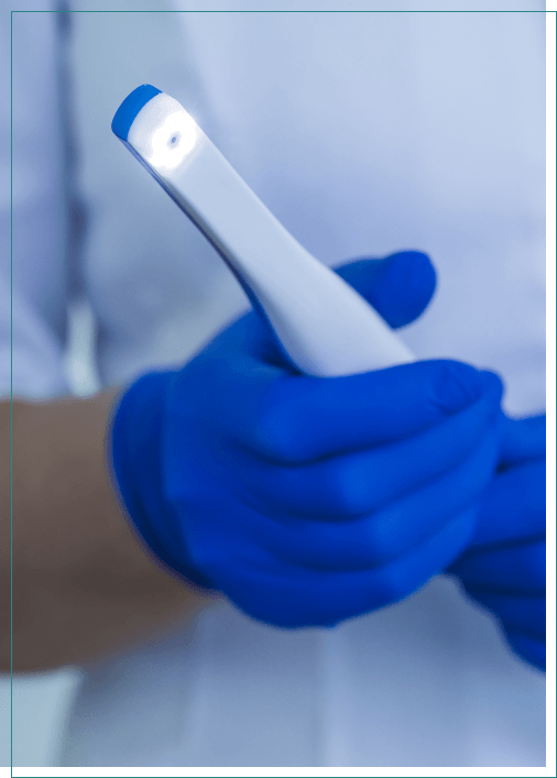 Dental professional holding a white intraoral camera