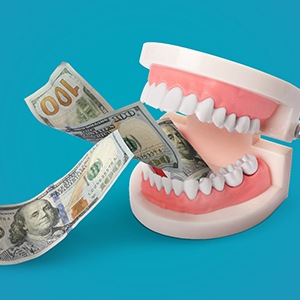 set of dentures with money going in between the teeth