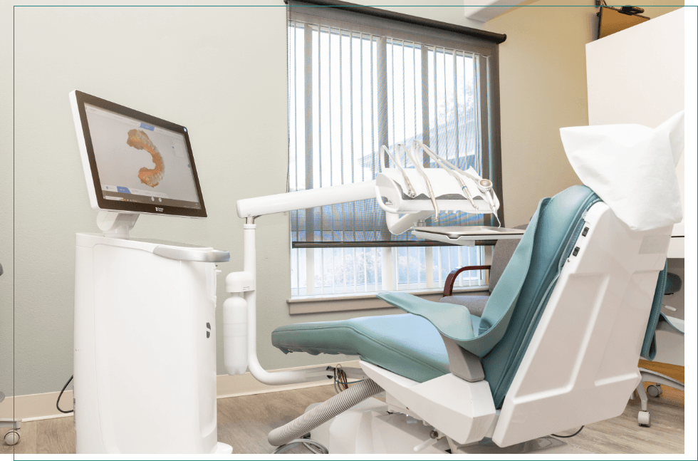 Dental treatment room with digital model of teeth on computer monitor
