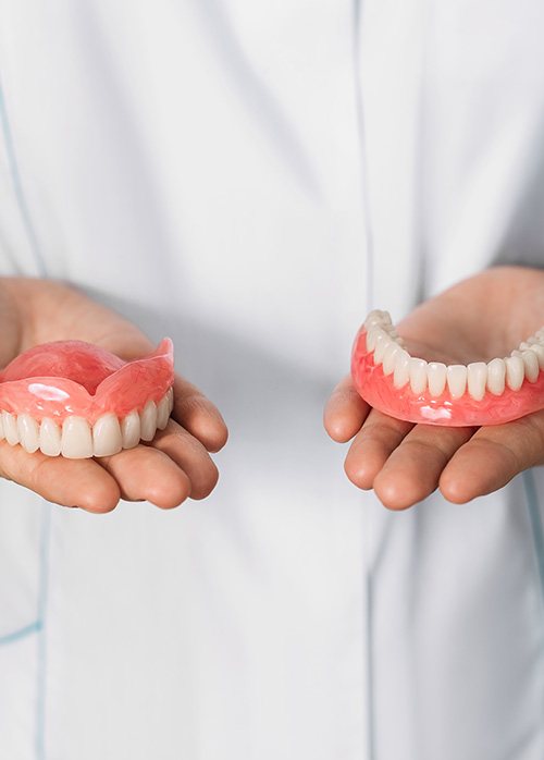 Hands holding two full dentures in Boise, ID