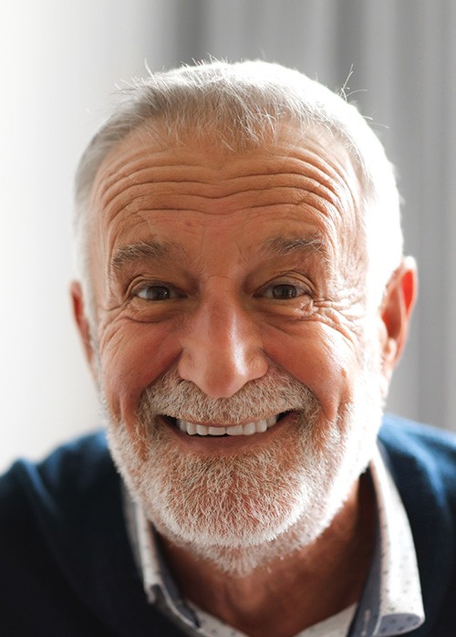 Bearded senior man in blue shirt smiling