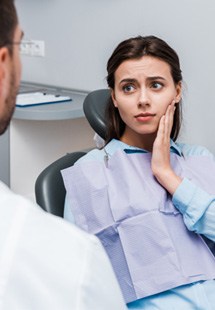 a person holding their cheek due to tooth pain